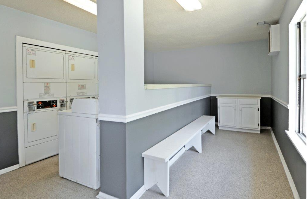 an empty kitchen with white cabinets and white benches
