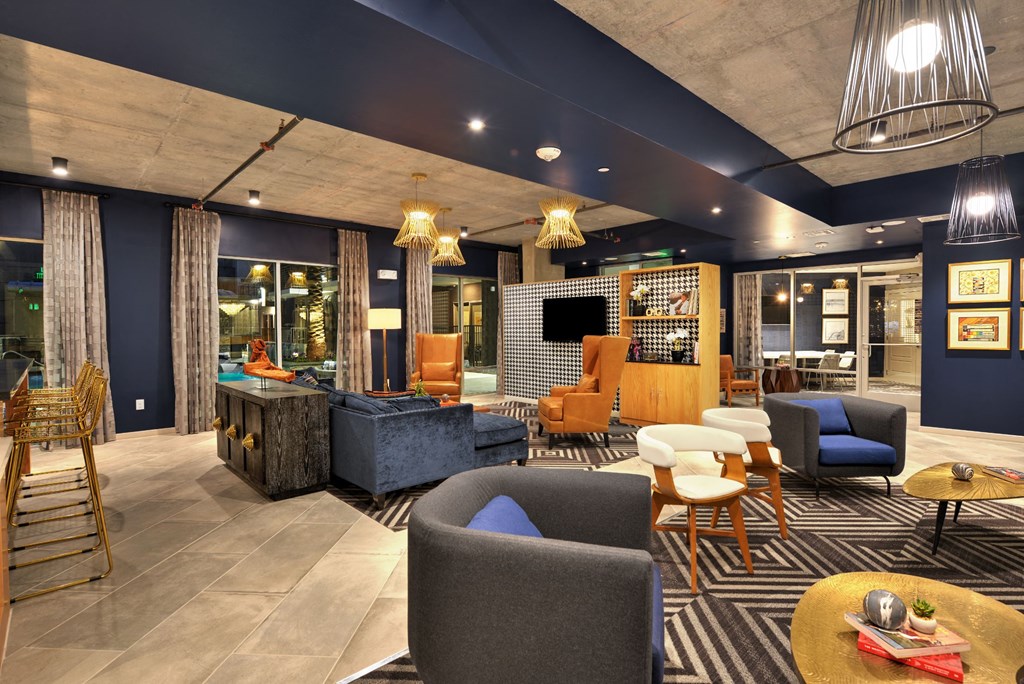 a lounge area with blue walls and orange chairs and blue couches