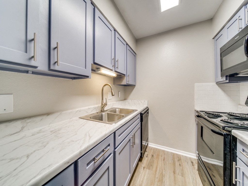 the kitchen of a home with white cabinets and a sink