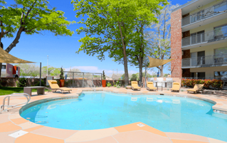 our apartments have a large swimming pool and a patio with chairs