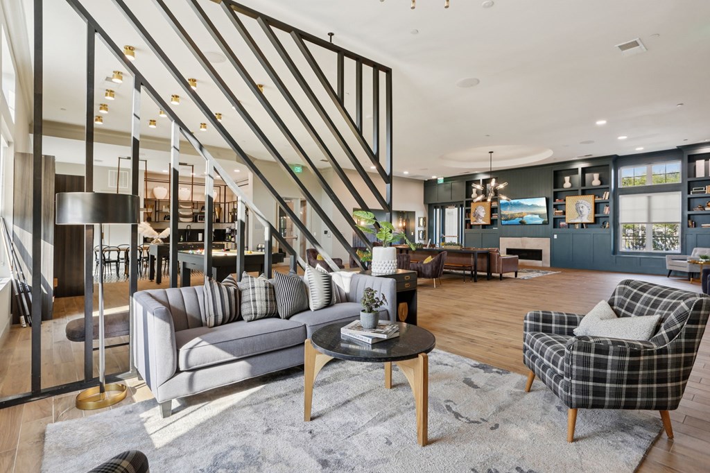 A living room with a grey sofa, a black and white checkered armchair, and a wooden coffee table.