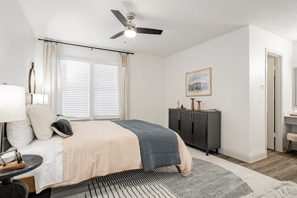 a bedroom with a bed and a ceiling fan