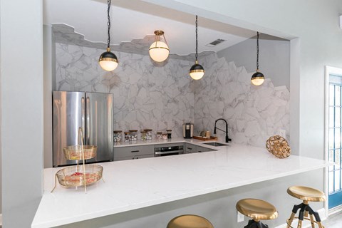 a kitchen with a white counter top and a stainless steel refrigerator