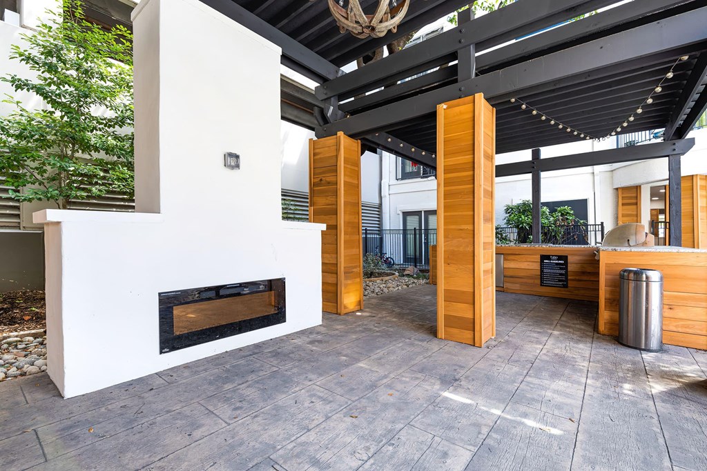 an outdoor kitchen with a fireplace and a bar