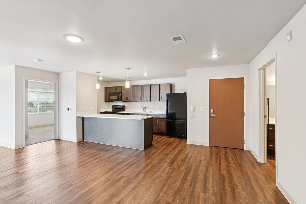A kitchen with a wooden floor and white walls.