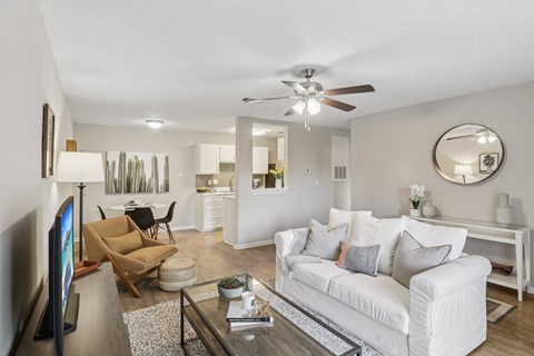 A living room with a white couch and a flat screen TV.