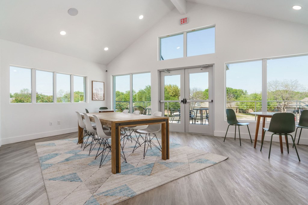 a dining room with a table and chairs and windows
