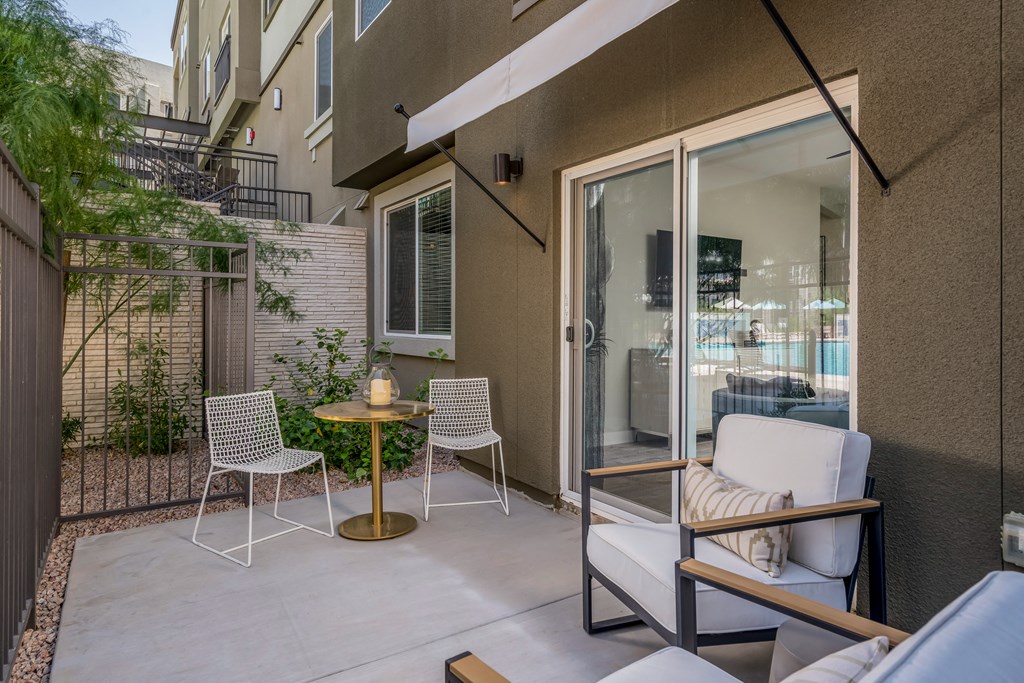 a patio with chairs and a table and a sliding glass door