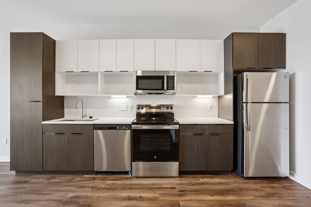 A modern kitchen with a stainless steel refrigerator and oven.
