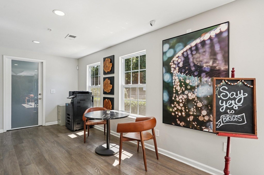 A room with a table and chairs and a painting of a butterfly on the wall.