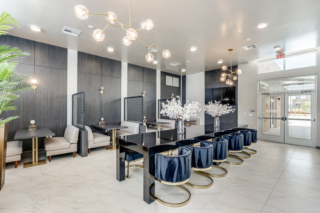 A modern dining room with a long table set for a meal.