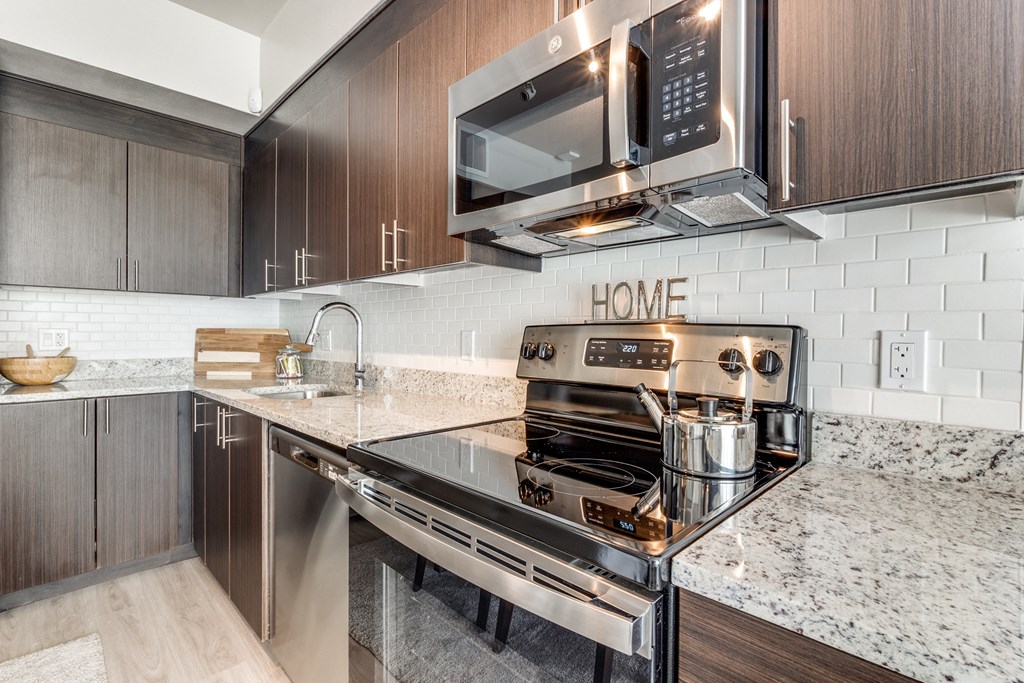 a kitchen with a stove top oven next to a sink and a microwave