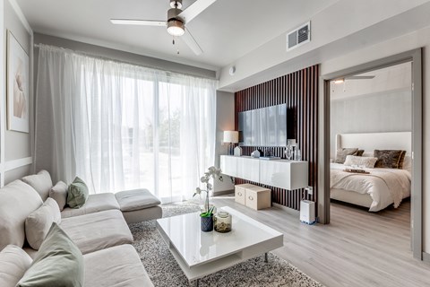 A modern living room with a white sofa and a glass coffee table.