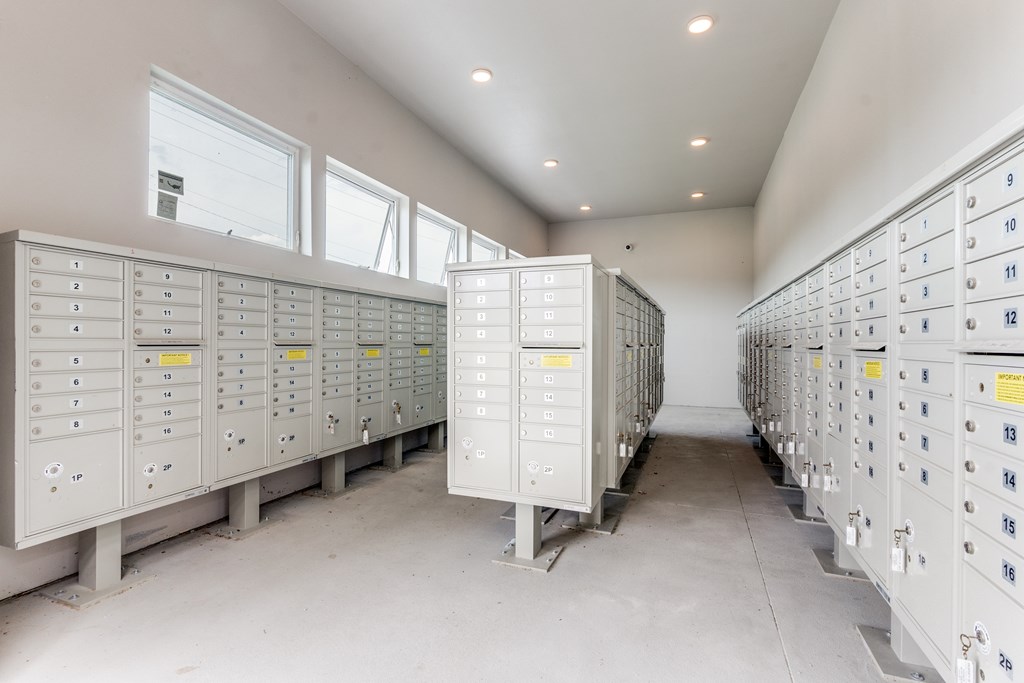 A row of white electrical boxes with yellow labels are lined up in a room.