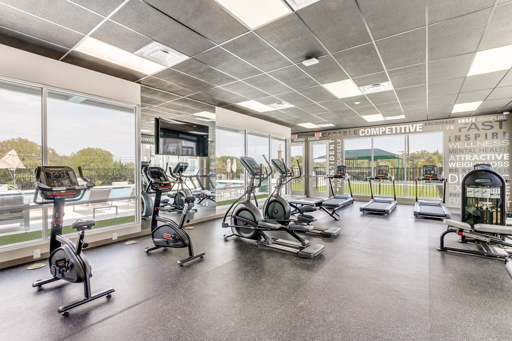 an image of a gym with cardio equipment and windows