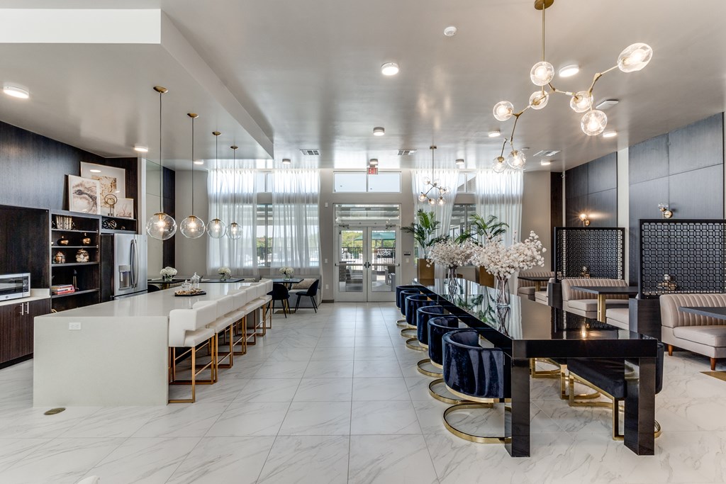 A modern kitchen with a long white island and bar stools.