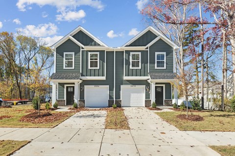 A two-story house with a garage and a driveway.