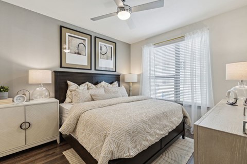 A bedroom with a large bed and a ceiling fan.