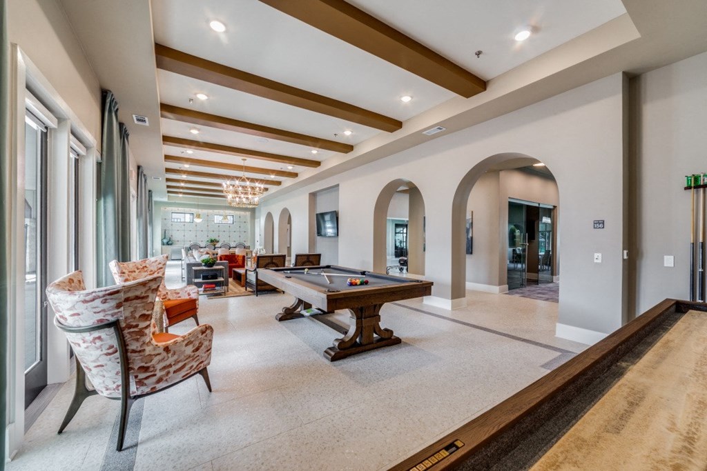 a game room with a pool table and chairs