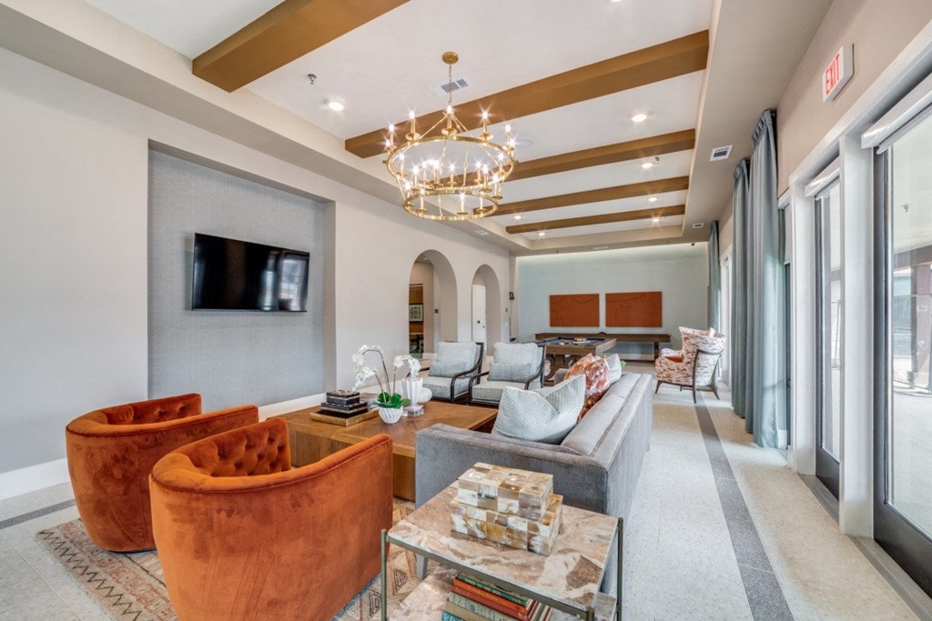 A living room with a television, a sofa, and a chandelier.
