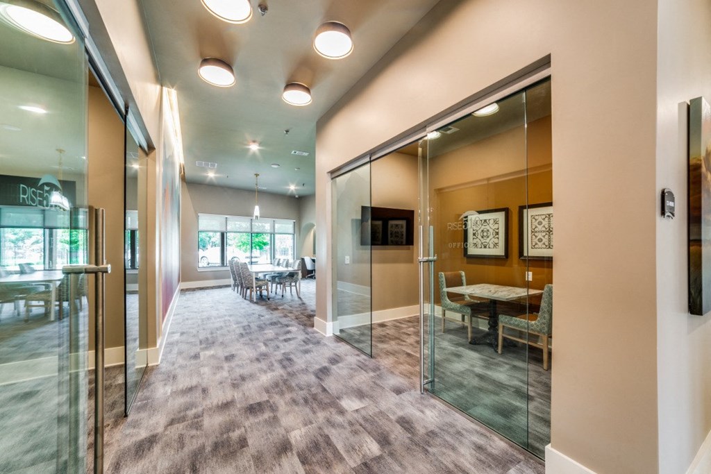 a conference room with glass walls and a table and chairs