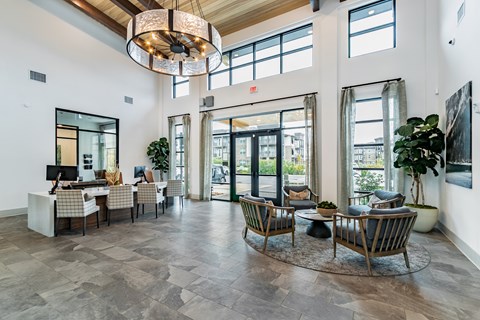 A large, open space with a grey floor and a chandelier hanging from the ceiling.