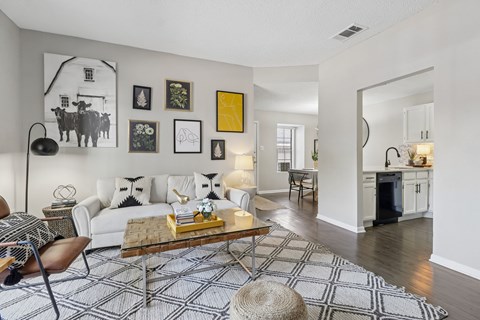 A living room with a white couch, a coffee table, and a rug with a geometric pattern.