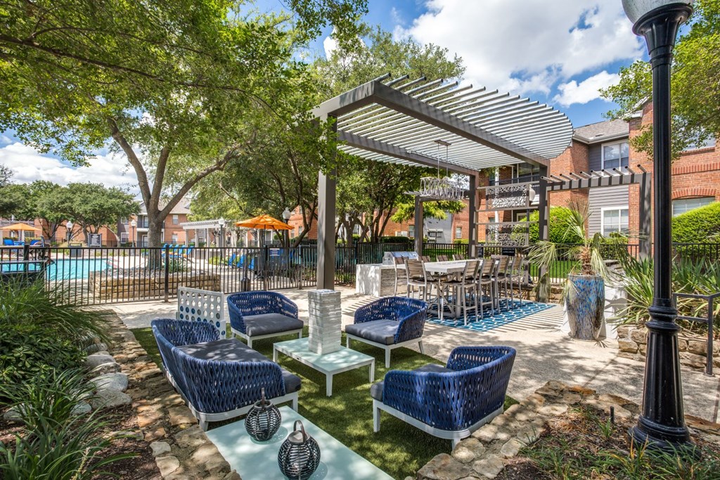a patio with blue chairs and tables and a pool