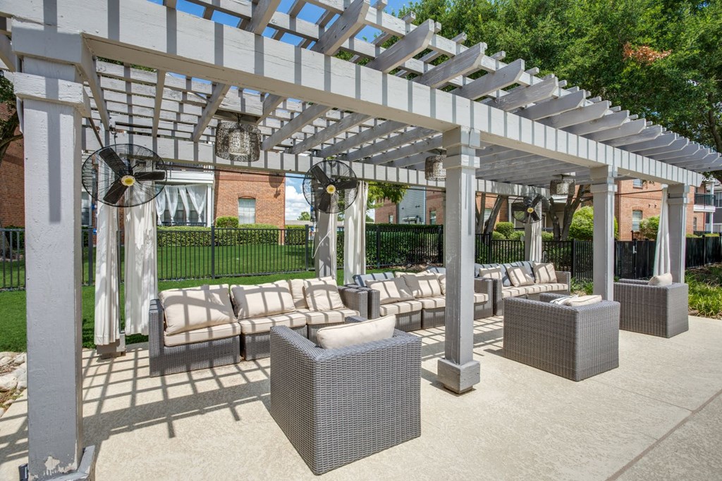 a covered patio with lounge chairs and a pergola