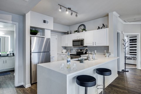 a kitchen with white cabinets and stainless steel appliances