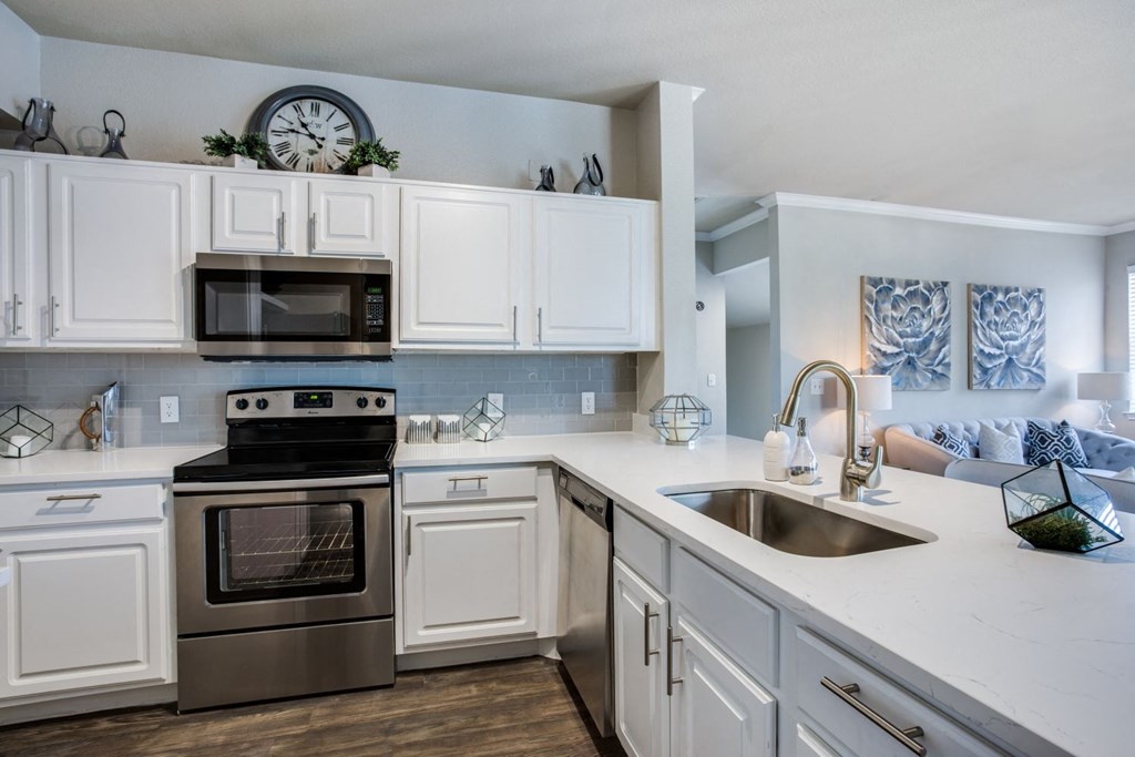 a kitchen with white cabinets and stainless steel appliances