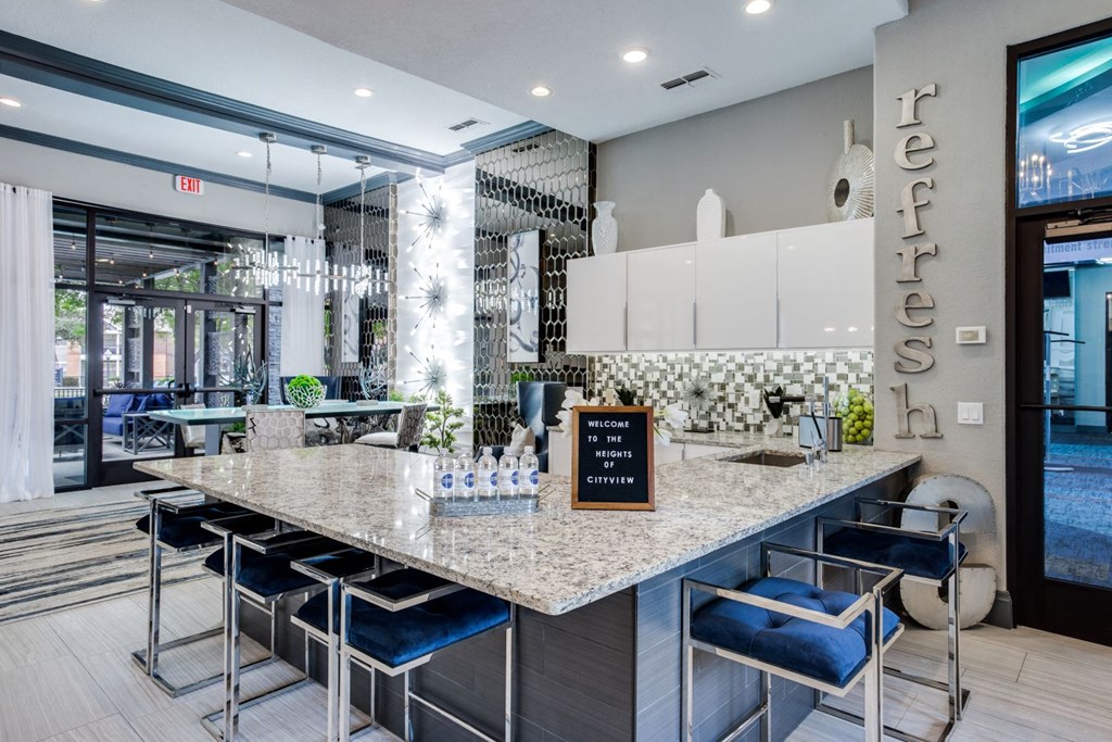 a kitchen with a marble counter top and blue chairs
