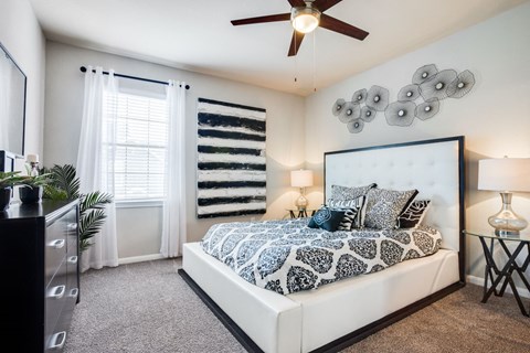 a bedroom with a bed and a ceiling fan