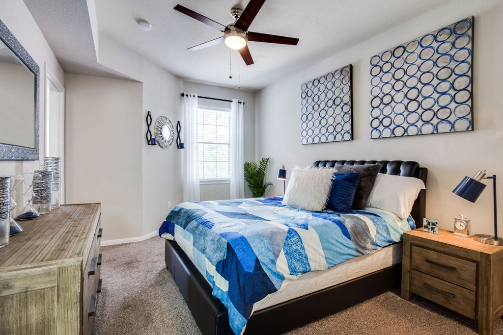 a bedroom with a bed and a ceiling fan