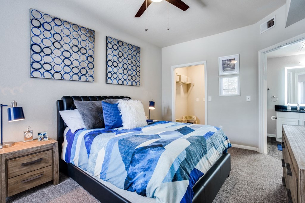 a blue and white bedroom with a bed and a ceiling fan