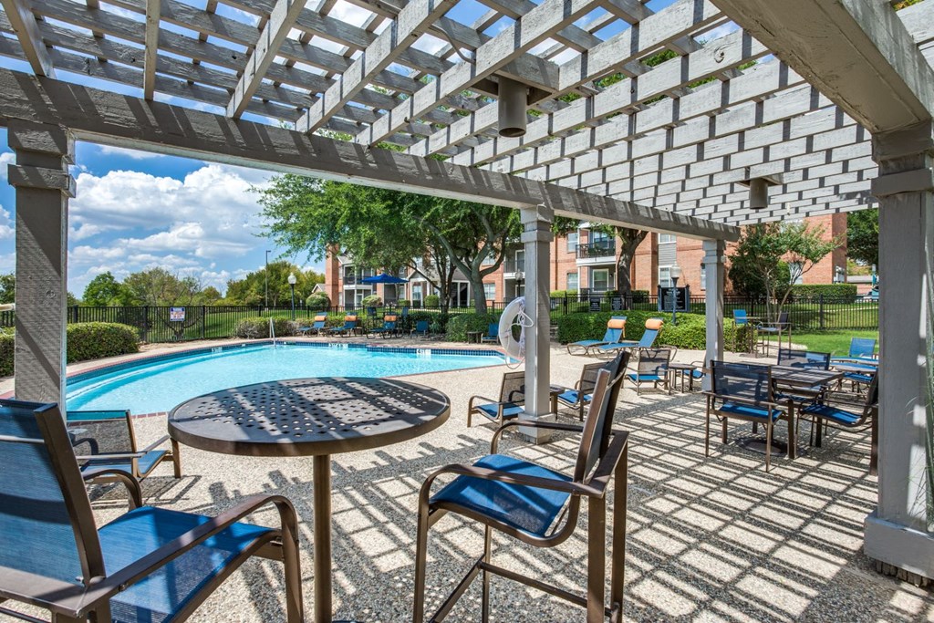 a patio with tables and chairs and a swimming pool