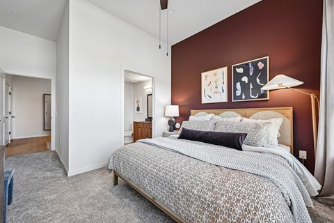 A bedroom with a large bed and a painting on the wall.