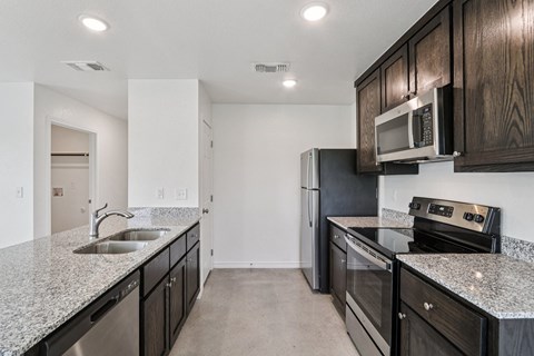A kitchen with black cabinets and stainless steel appliances.