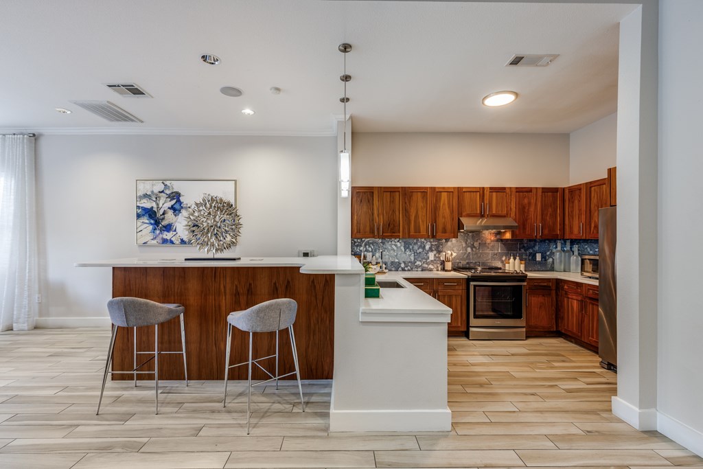 A kitchen with a bar area and two stools.