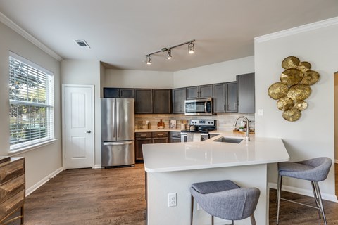 A kitchen with a white island and a refrigerator.