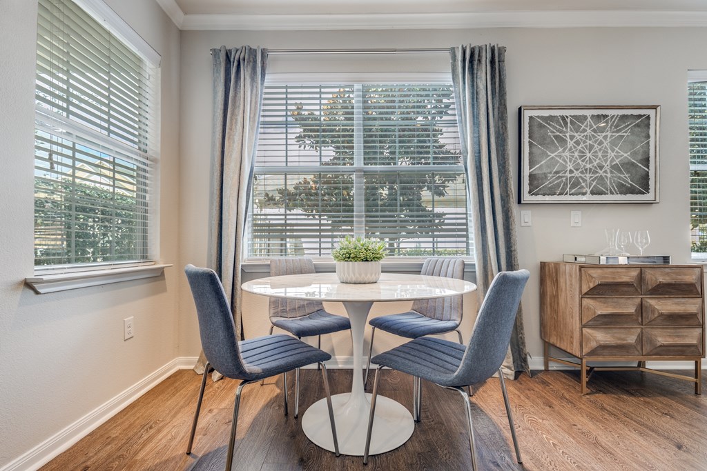 A dining room with a table and chairs.