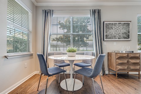 A dining room with a table and chairs.