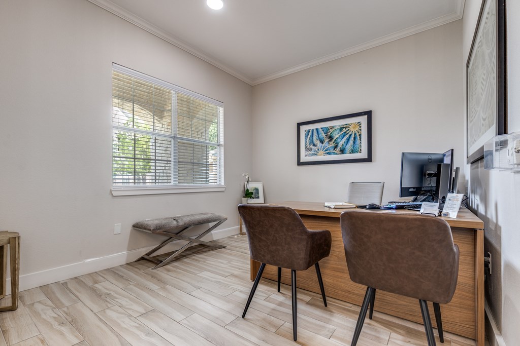 A room with a desk and two chairs.