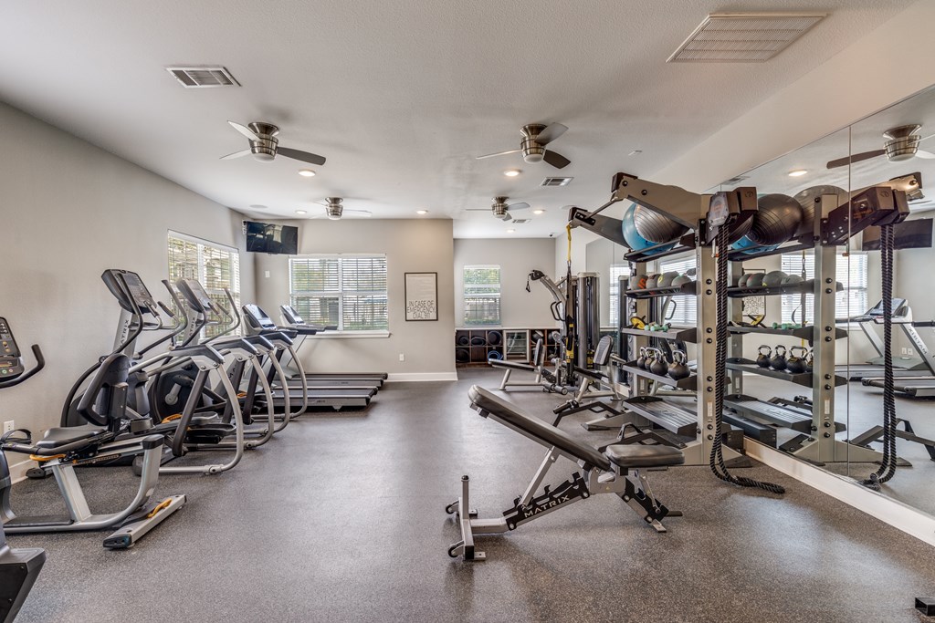 A spacious gym with treadmills, elliptical machines, and weightlifting equipment.