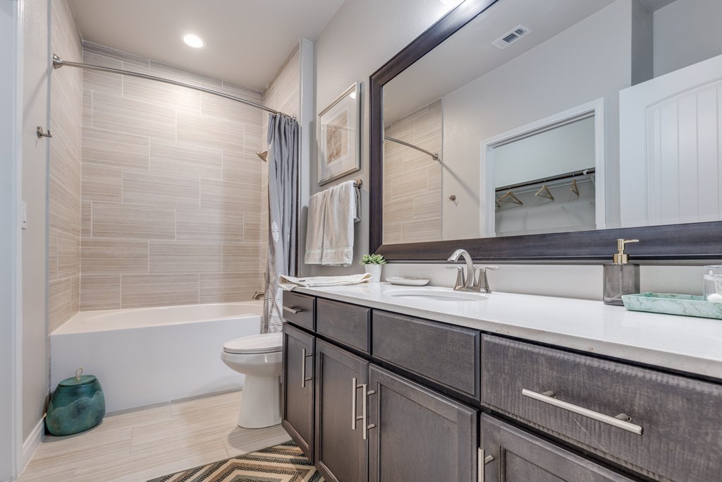 A bathroom with a white tub, sink, and toilet.