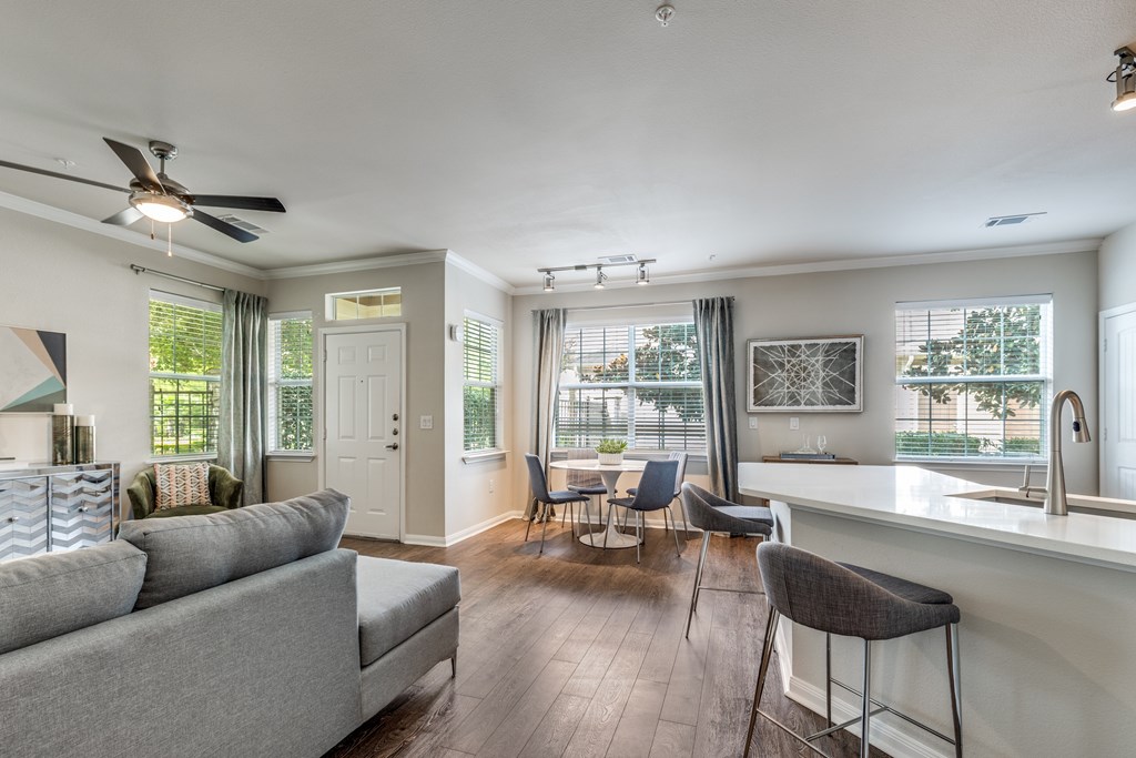 A living room with a grey couch and a bar area.