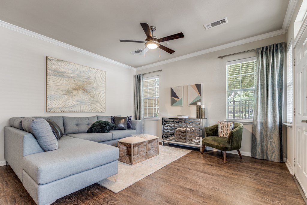 A living room with a grey couch, a green armchair, and a wooden coffee table.