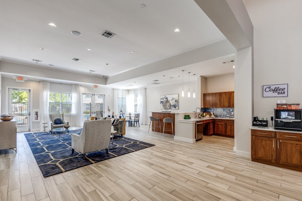 A spacious living room with a kitchen area in the background.