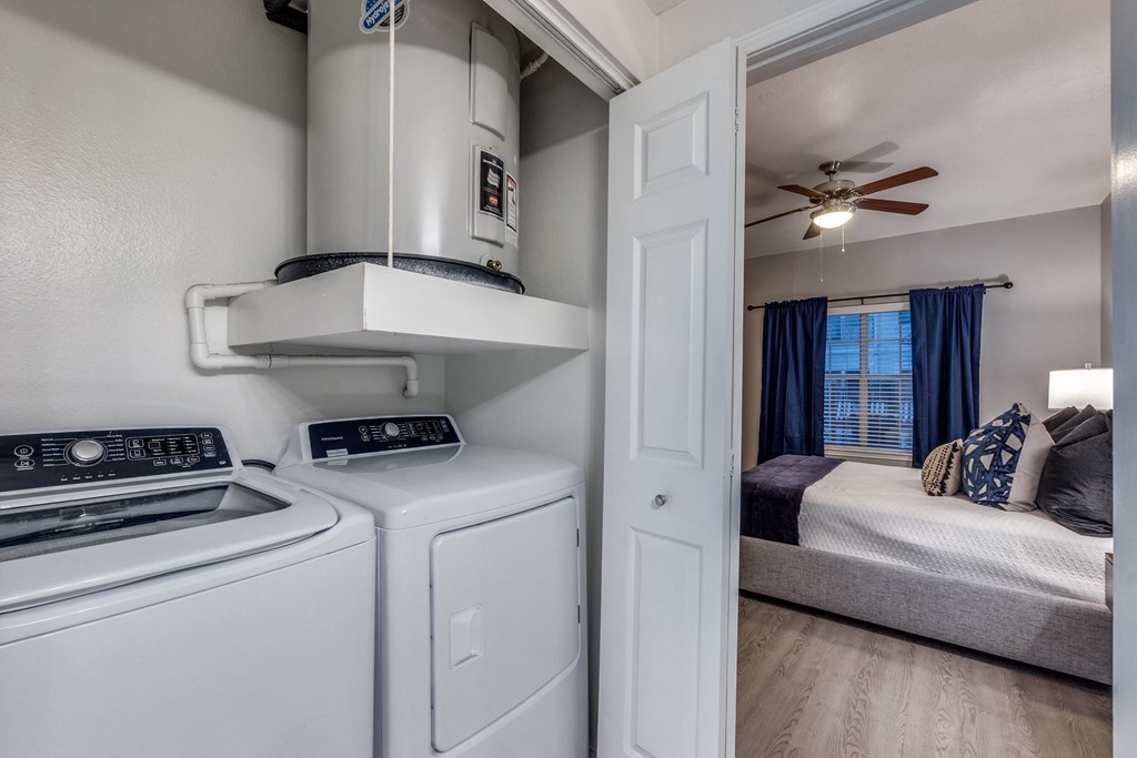 the washer and dryer in the laundry room of a home with a bedroom