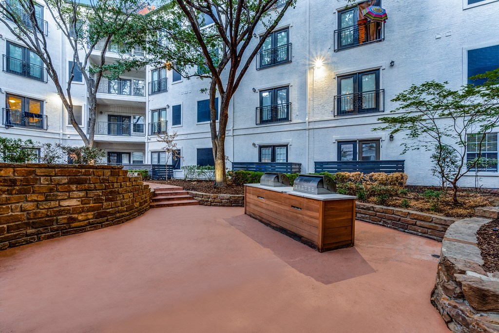 an outdoor area with a desk and trees and a building